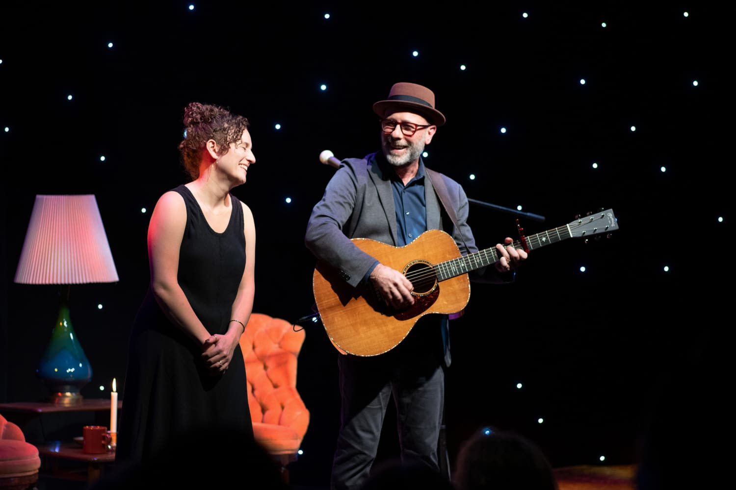 Danielle Wertz and Robbie Schaefer is speak to the audience during an intimate, graceful, and moving cabaret-style show at GableStage in “Both Sides Now: The Music and Lives of Joni Mitchell & Leonard Cohen.” (Photo by Magnus Stark)