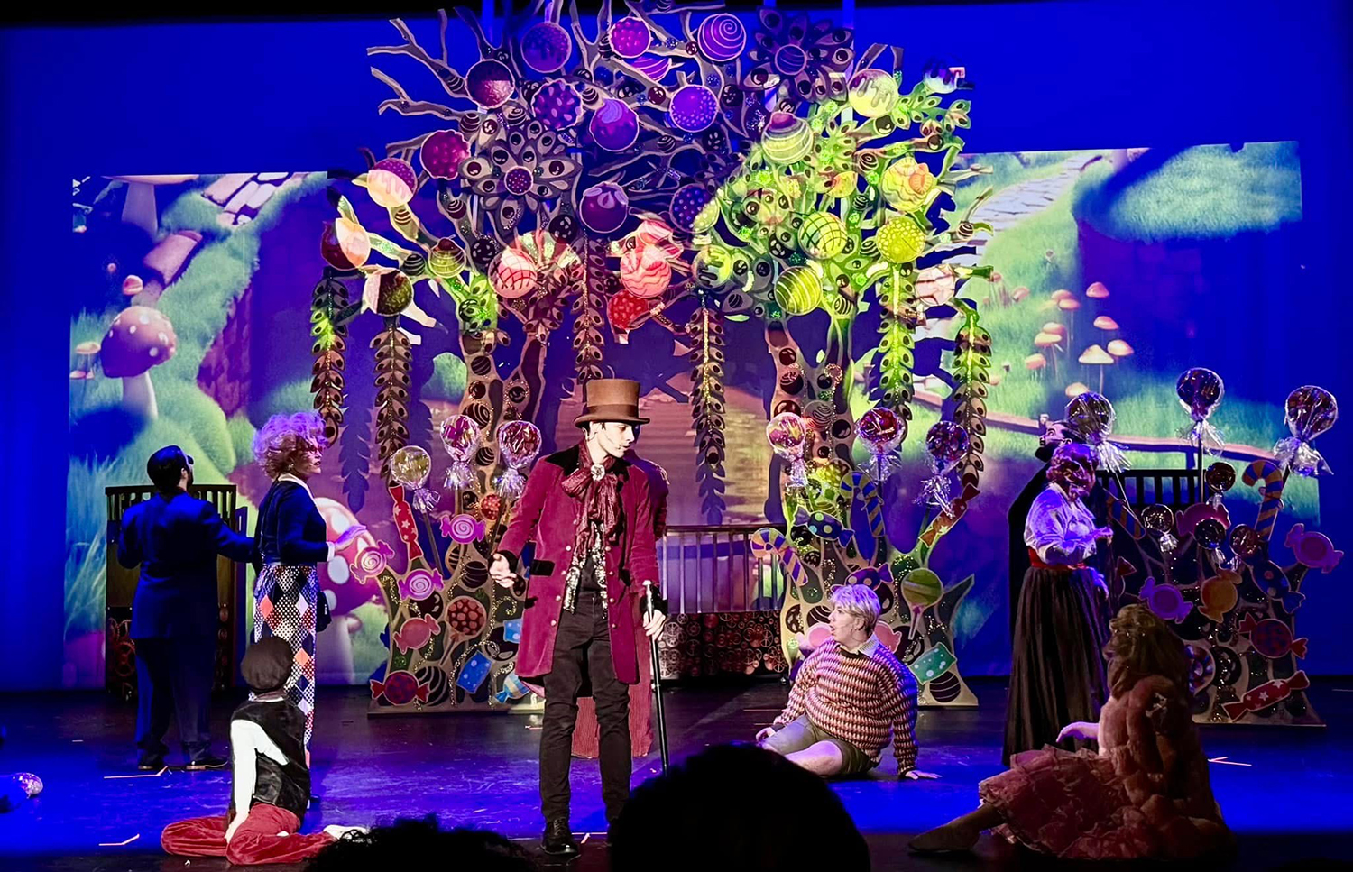 Willy Wonka (Benjamin Leon IV) deals with unruly children such as Augustus Gloop (Anthony Mallen, pictured to Wonka's left).