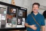 Photographer Brett Hufziger next to his work featuring New Sagamore Suites.