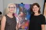 Susan Askew with Miami Herald columnist Debra Krieff Leibowitz next to Femme Fatale exhibit artist Mr Cenz's piece titled Resolution.